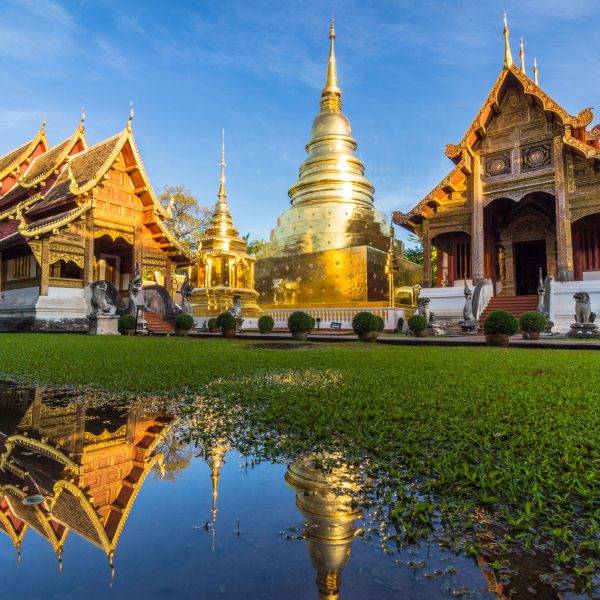 Wat Phra Singh temple, blue sky and reflection in water. Chiang Mai, Thailand.